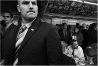 A Secret Service agent keeps watch as Obama lunches on a cheesesteak in Philly.